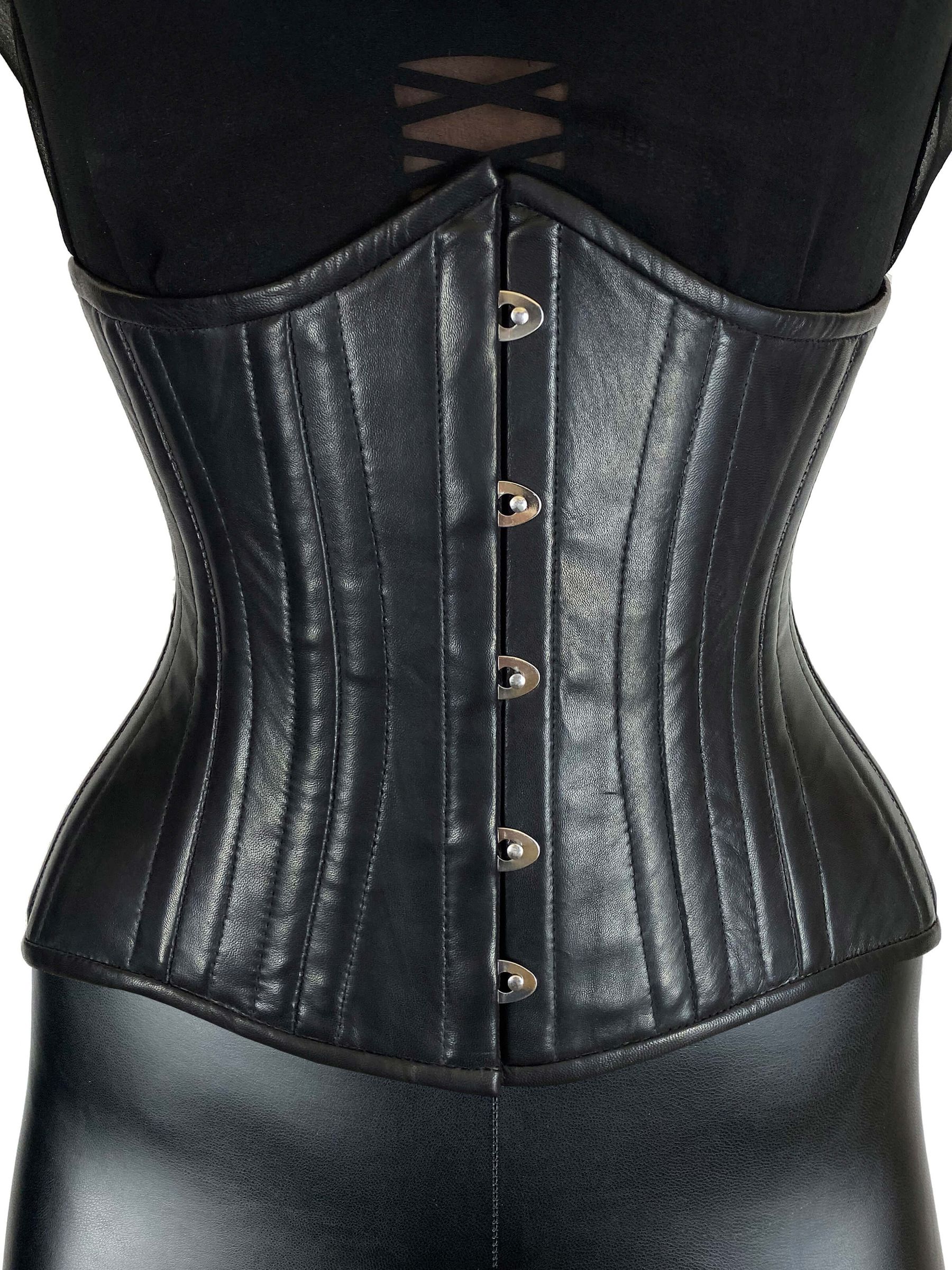 Schwarzes Echtleder Korsett Cloudette mit Frontverschluss und figurformender Taillierung, getragen über schwarzer Kleidung.