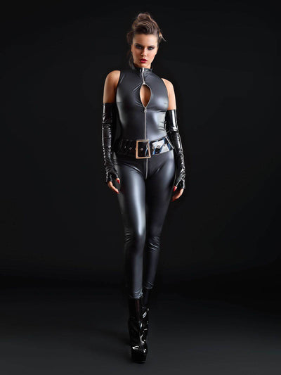 Frau posiert im ärmellosen Kunstleder-Catsuit mit Reißverschluss, Lackgürtel und Plateau-Heels vor schwarzem Hintergrund.